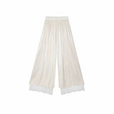 Flat lay of apricot cream pleated wide-leg pants with an elastic waistband, side tie, and layered lace hem, crafted from 100% polyester.