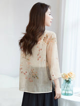 Back view of a beige 100% silk blouse with a relaxed fit and floral print, highlighting the elegant drape and breathable feel.
