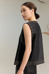 Side view of a women's black silk sleeveless top with intricate bead embroidery, showcasing the luxurious drape of the 100% silk fabric and the V-neck design.