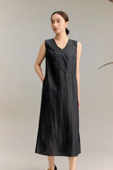 Full body shot of a black silk sleeveless V-neck dress with side pockets and A-line silhouette, crafted from 100% mulberry silk, featuring a midi length and side slits for easy movement.