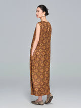 Side view of a brown silk sleeveless A-line dress with a round neckline, relaxed fit, and side pockets, paired with flat shoes.