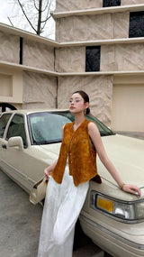 Side view of a women's amber brown Qipao vest top, featuring a button-down front and V-neckline, styled with white palazzo trousers.