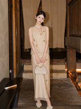 Front view of a champagne Cheongsam set featuring a sheer neckline and 3D floral appliqués, holding a pleated handbag.