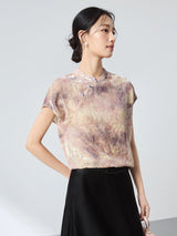 Side view of a champagne floral top with a stand collar, showcasing the elegant drape and shimmering texture of the 65.6% mulberry silk blend.