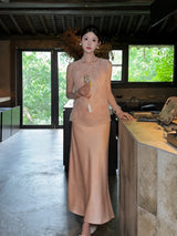 Front view of a champagne satin A-line maxi skirt styled with a matching embroidered vest, highlighting the smooth, lustrous finish of the fabric.