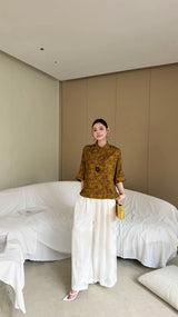 Front view of a loose-fit Cheongsam blouse with Mandarin collar, olive green metallic fabric, perfect for pairing with white flowy pants or skirts.