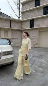 Full body shot of a cream yellow co-ord set, featuring a short-sleeve Qipao top and matching wide-leg trousers.