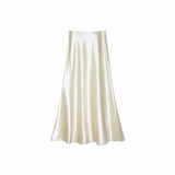Flat lay of a cream satin A-line maxi skirt with a high waist and smooth flowing drape, crafted from 100% polyester.