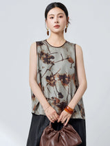 Front view of a grey 100% mulberry silk tank top with a round neckline and brown trim, featuring a relaxed fit and abstract ink wash print.