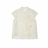 Flat lay of an ivory short-sleeve Cheongsam top with floral embroidery, sequins, and side tie details, crafted from a Lyocell-metallic blend.