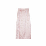 Flat lay of a pink midi skirt with floral jacquard pattern and side button details, matching the embroidered top.
