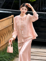 Model wearing a pink embroidered top and matching satin skirt, holding a pink handbag, highlighting the flowy and elegant silhouette.