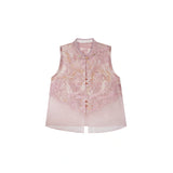 Flat lay of a pink sleeveless vest with gold metallic buttons, lace trim, and a layered sheer hem, crafted from a Lyocell-metallic blend.