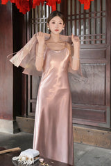 Close-up of a pink satin dress with a sheer pink jacket draped over the shoulders, highlighting the soft drape of the 100% polyester fabric.