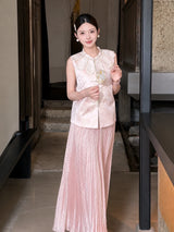Front view of a pink shiny pleated maxi skirt styled with a pearl-embellished vest, holding a fan, showcasing the elegant 100% polyester fabric.