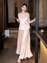 Side view of a pink shiny pleated maxi skirt worn with a pearl-trimmed top, highlighting the flowy silhouette and comfortable fit.
