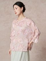Side view of a pink silk top with a round neckline, highlighting the flowing drape and elegant cutwork pattern.