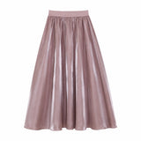 Flat lay of a purple shiny maxi skirt with an elastic waistband and flowy silhouette, crafted from 100% polyester.