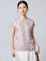 Model wearing a light purple 94% mulberry silk top with a stand collar, asymmetrical button placket, and butterfly jacquard pattern, paired with a white skirt.