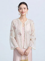 Front view of a women's sheer long-sleeve cover-up featuring delicate pink and purple floral embroidery with scalloped pearl trim.
