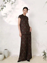 Full body shot of a Chinese style silk co-ord set with a short sleeve Cheongsam top and flowy palazzo pants, crafted from 100% mulberry silk with elegant brocade texture.