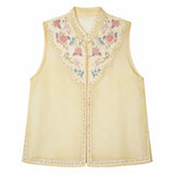 Flat lay of a yellow sleeveless Cheongsam vest with a mandarin collar, delicate floral embroidery, and pearl button details, crafted from 100% polyester.
